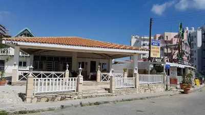 a small building with a white fence in front of it at ZORBAS No 2 in Larnaka