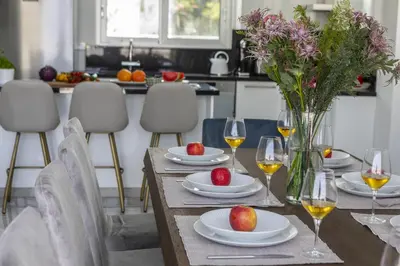 a dining room table with plates and glasses of wine at Fig Tree Bay Residences 7 in Protaras