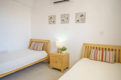 a bedroom with two beds and a night stand at Emily apartment in Paralimni