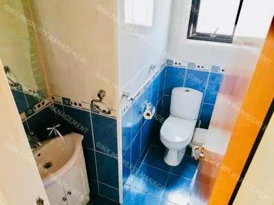 a blue tiled bathroom with a toilet and a sink at Merika Complex 1 Hou.32 in Larnaka