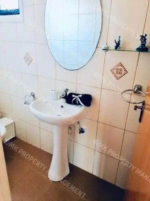 a bathroom with a white sink and a mirror at Merika Complex 1 Hou.32 in Larnaka