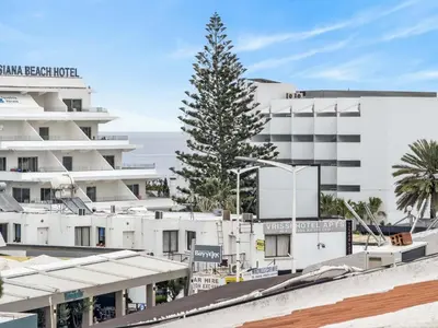 a palm tree in front of a white building at Sofia's Seaview in Protaras