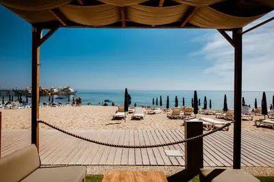 a beach with chairs and umbrellas and the ocean at Sofia's Seaview in Protaras