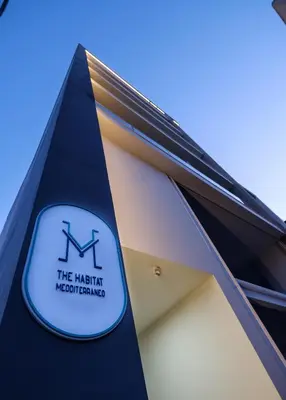 a sign on the side of a building at The Habitat Mediterraneo - Self Check-in in Larnaka
