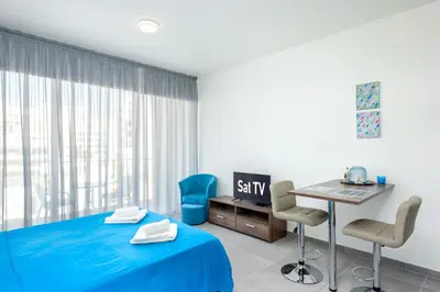 a room with a bed and a table and chairs at The Habitat Mediterraneo - Self Check-in in Larnaka
