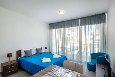 a bedroom with a blue bed and a blue chair at The Habitat Mediterraneo - Self Check-in in Larnaka