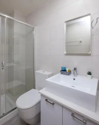 a white bathroom with a toilet and a sink at The Habitat Mediterraneo - Self Check-in in Larnaka