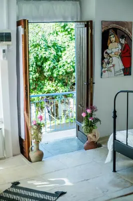a bedroom with a door open to a balcony at Cecilias Courtyard in Malia