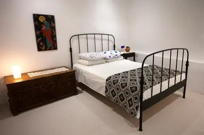 a bedroom with a bed and a table with a candle at Cecilias Courtyard in Malia