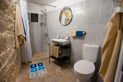 a bathroom with a white toilet and a sink at Cecilias Courtyard in Malia