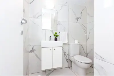 a white bathroom with a toilet and a sink at Villa Mirella in Protaras