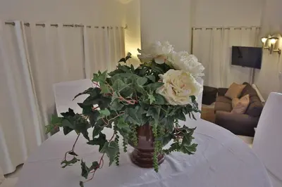 a vase filled with white flowers on a table at Nestor Hillside House by TrulyCyprus in Moniatis