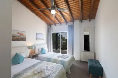 a bedroom with two beds and a large window at Rosie Villa in Ayia Napa