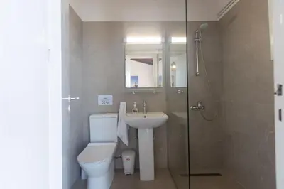 a bathroom with a toilet and a sink and a shower at Rosie Villa in Ayia Napa