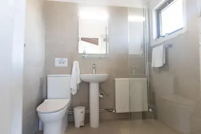 a bathroom with a toilet and a sink and a shower at Rosie Villa in Ayia Napa