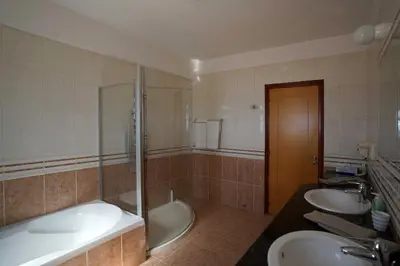 a bathroom with two sinks and a tub and a shower at Sunset Cliff Villa Panoramic Sea Views Private Heated Pool Included in Pissouri