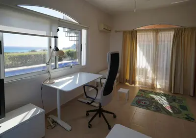 a room with a desk and a chair and a window at Sunset Cliff Villa Panoramic Sea Views Private Heated Pool Included in Pissouri