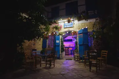 a patio with tables and chairs at night at Serenity Boutique House in Vouni