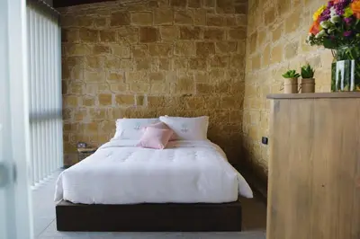a bedroom with a white bed with a pink pillow at Serenity Boutique House in Vouni