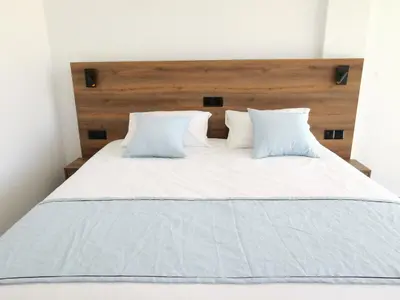 a bed with white sheets and pillows at Shalos Studios in Ayia Napa