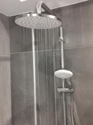 a shower with a shower head and a stool in a bathroom at Shalos Studios in Ayia Napa