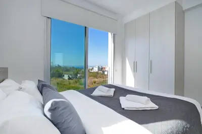 a bedroom with a bed with a large window at Villa Carmen in Protaras