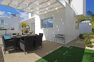 a dining area with a table and chairs on a patio at Villa Sunday in Ayia Napa