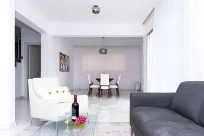 a living room with a couch and a table with a bottle of wine at Villa Sunday in Ayia Napa