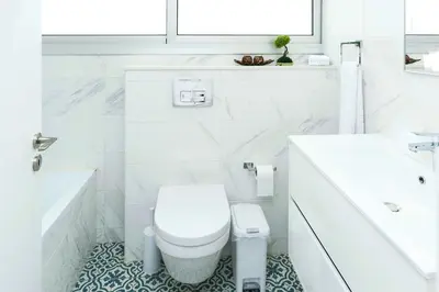 a white bathroom with a toilet and a sink at Villa Sunday in Ayia Napa