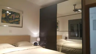 a bedroom with two beds and a mirror at Kennedy Deluxe Suites in Nicosia