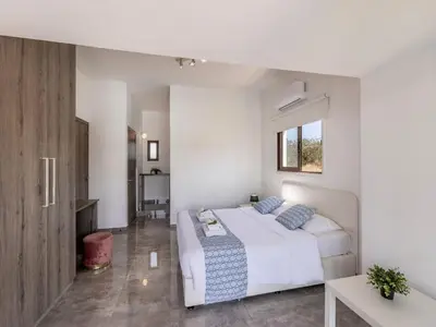 a white bedroom with a bed and a window at Villa Socrates in Protaras