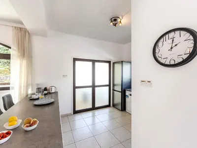 a room with a clock and a table with fruit on it at Villa Socrates in Protaras