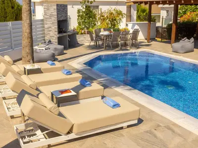 a pool with chaise lounge chairs and a swimming pool at Villa Socrates in Protaras