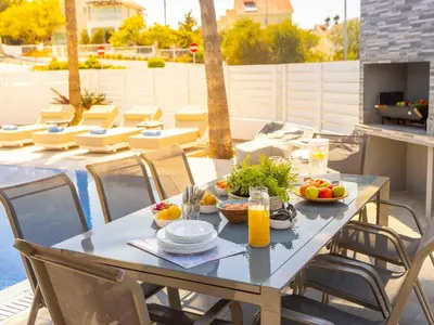 a table with bowls of fruit on a patio at Villa Socrates in Protaras