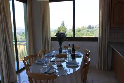 a dining room table with a view of a kitchen at Yiannos House in Evrykhou