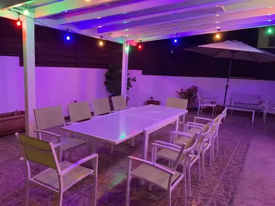 a large white table and chairs with purple lights at Villa Julia in Ayia Napa