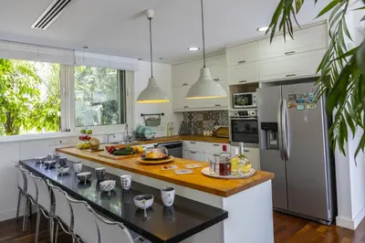 a kitchen with white cabinets and a wooden counter top at Larnaca Villa Marisol Kiti in Larnaka