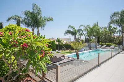 a swimming pool in a resort with trees and plants at Oscar Domain Villa in Protaras