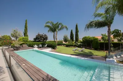 a swimming pool in a villa with palm trees at Oscar Domain Villa in Protaras