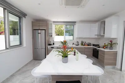 a kitchen with a white table and a refrigerator at Fig Tree Bay Residences 1 Lantiana Villa in Protaras