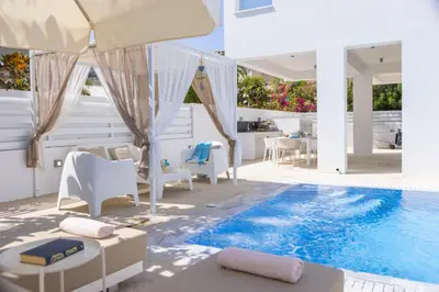 a patio with a pool and chairs and a house at Fig Tree Bay Residences 1 Lantiana Villa in Protaras