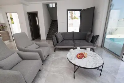 a living room with a couch and a table at Fig Tree Bay Residences 1 Lantiana Villa in Protaras