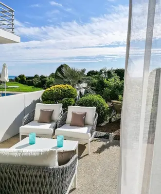 a patio with two couches and a table at Atlantis Gardens in Mazotos