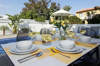 a table with white plates and glasses of wine at Villa Maritime in Protaras