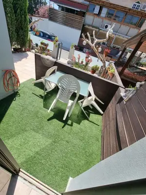 a patio with a table and two chairs on a lawn at Town centre suites in Larnaka