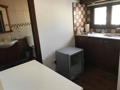 a small kitchen with a sink and a television at Town centre suites in Larnaka