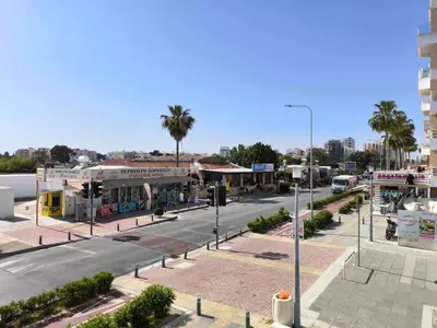 an empty street in a city with palm trees at 13 Sandy Beach Mackenzie in Larnaka