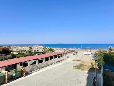 a building on a beach with the ocean in the background at 13 Sandy Beach Mackenzie in Larnaka