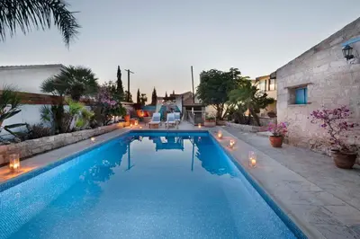 a large swimming pool with lights in a backyard at Cottage Houses in Pendakomo