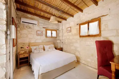 a bedroom with a white bed and a red chair at Cottage Houses in Pendakomo